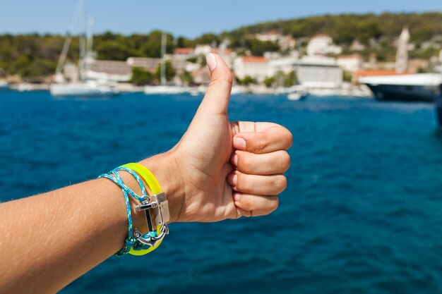 Cerrar la mano mostrando el pulgar hacia arriba gesto en el mar