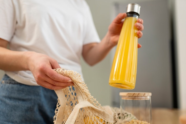 Foto gratuita cerrar mano sosteniendo botella de jugo