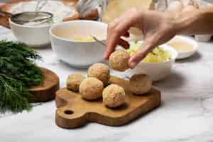 Foto gratuita cerrar mano sosteniendo croqueta de comida