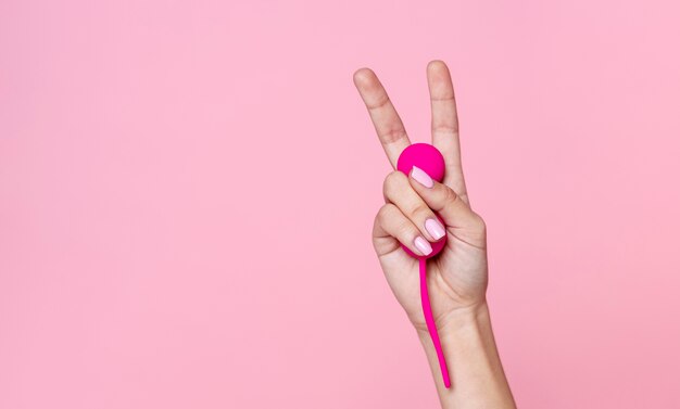 Cerrar mano sosteniendo juguete sexual rosa