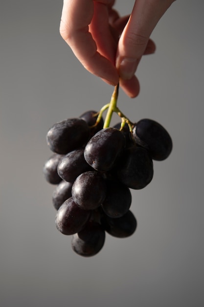 Cerrar mano sosteniendo uvas para el verano