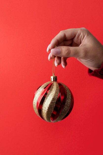 Cerrar mano sujetando el globo de Navidad