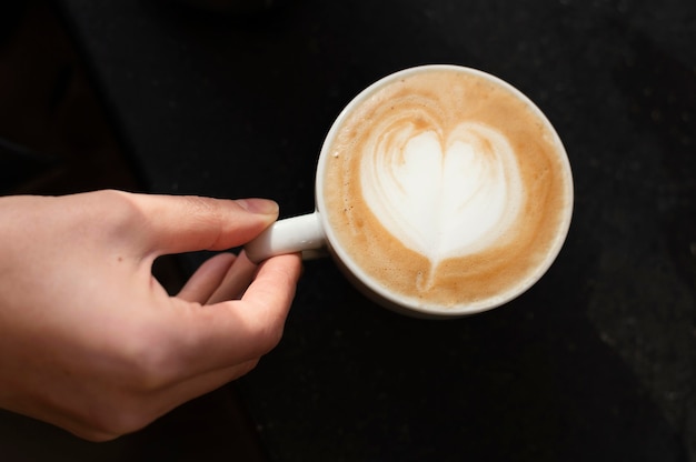 Cerrar la mano y la taza de café