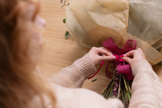 Cerrar las manos atando la cinta rosa