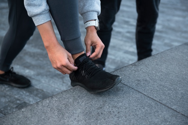 Cerrar las manos atando los cordones de los zapatos