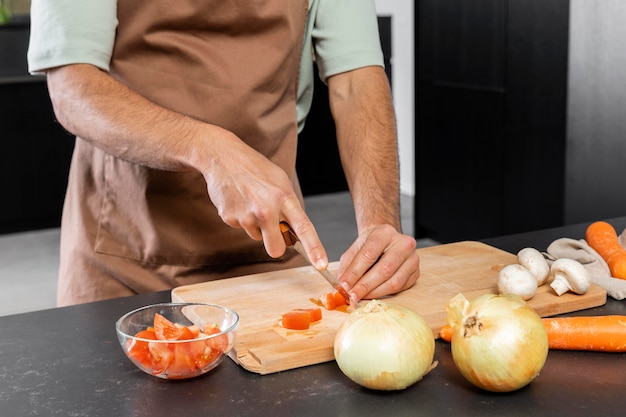 Foto gratuita cerrar las manos cortando tomate