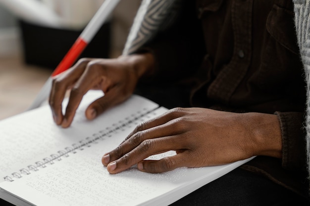 Cerrar las manos leyendo el cuaderno braille