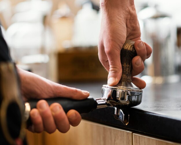 Cerrar las manos moliendo granos de café