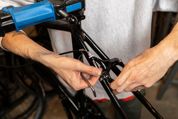 Cerrar las manos reparando bicicleta en la tienda