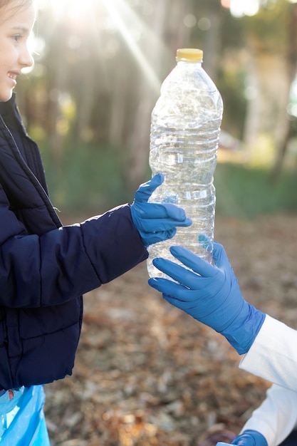 Cerrar las manos sosteniendo una botella de plástico