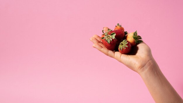 Cerrar manos sosteniendo fresas