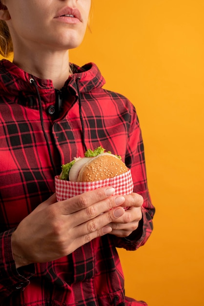 Foto gratuita cerrar manos sosteniendo hamburguesa