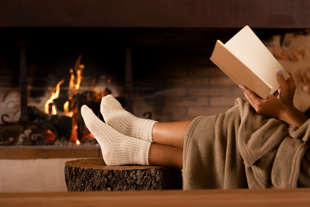 Foto gratuita cerrar las manos sosteniendo el libro junto al fuego