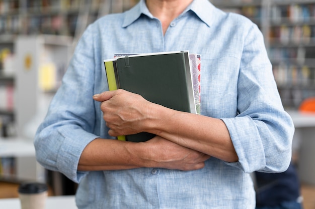 Cerrar manos sosteniendo libros