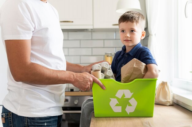 Cerrar las manos sosteniendo la papelera de reciclaje