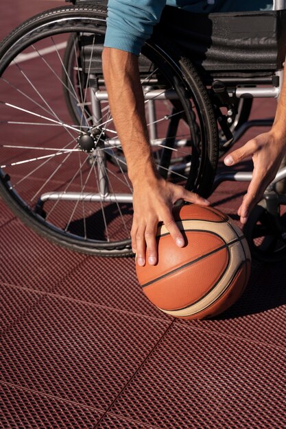 Cerrar las manos sosteniendo la pelota de baloncesto