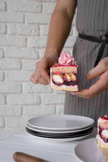 Foto gratuita cerrar las manos sosteniendo la rebanada de pastel