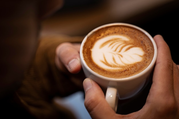 Cerrar las manos sosteniendo la taza de café