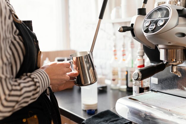 Cerrar las manos sosteniendo la taza metálica