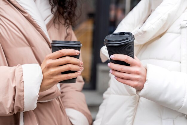Foto gratuita cerrar manos sosteniendo tazas de café