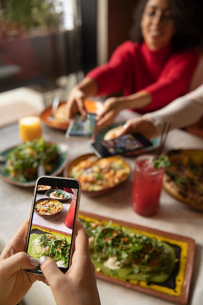 Cerrar las manos tomando fotos de comida