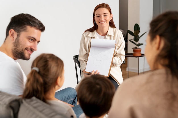 Foto gratuita cerrar miembros de la familia hablando con el terapeuta