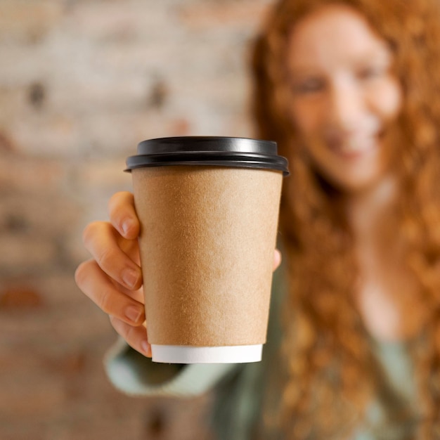 Cerrar mujer borrosa sosteniendo la taza