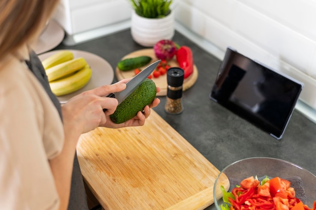 Foto gratuita cerrar mujer cortando pepino