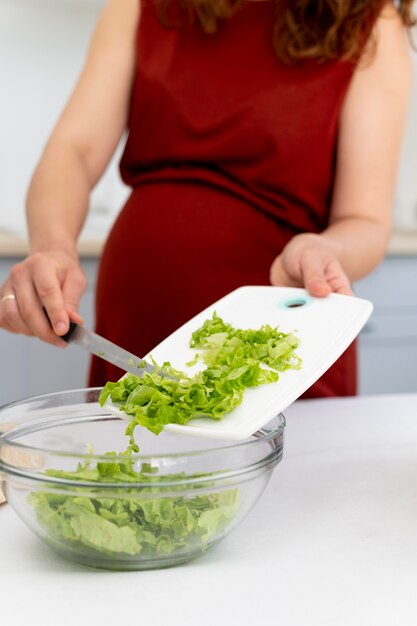 Cerrar mujer embarazada cocinando