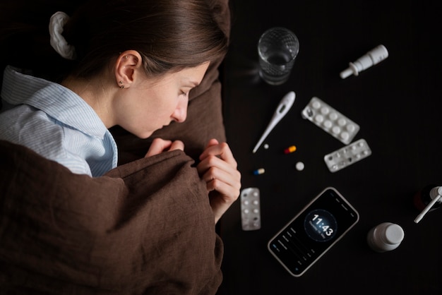Cerrar mujer enferma en la cama con pastillas