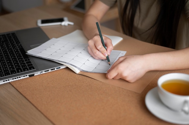 Cerrar mujer escribiendo con lápiz