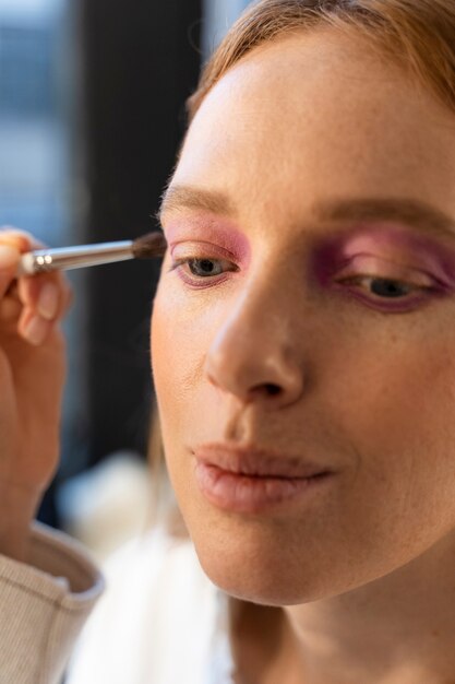 Cerrar mujer haciendo su maquillaje