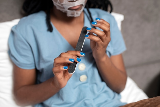 Cerrar mujer haciendo sus uñas ángulo alto