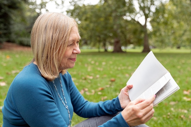 Cerrar mujer leyendo al aire libre