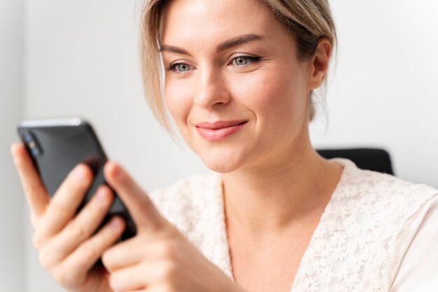 Cerrar mujer de negocios sosteniendo teléfono