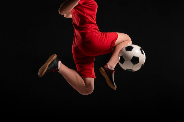 Cerrar mujer pateando la pelota con la rodilla