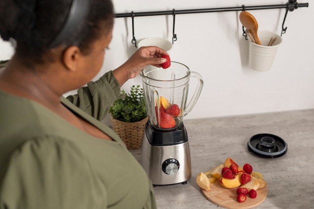 Cerrar mujer preparando batido