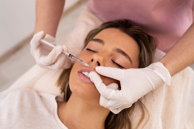 Cerrar mujer recibiendo relleno de labios