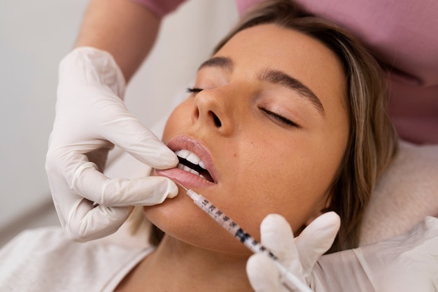 Cerrar mujer recibiendo relleno de labios