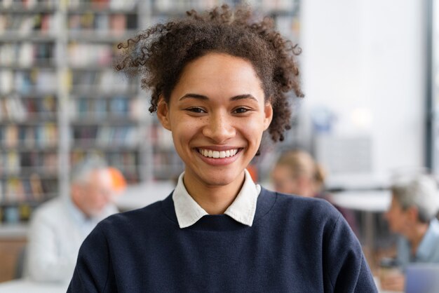 Cerrar mujer sonriente en biblioteca