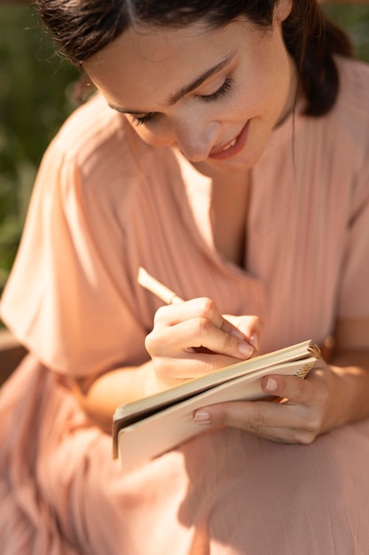 Cerrar mujer sonriente escribiendo