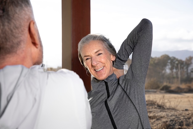 Foto gratuita cerrar mujer sonriente estirando al aire libre