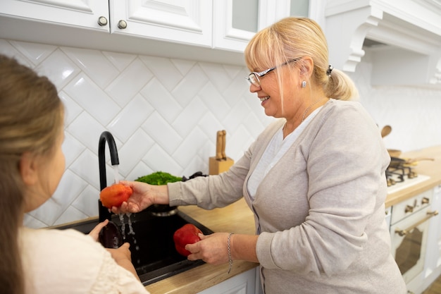 Cerrar mujer sonriente lavando verduras