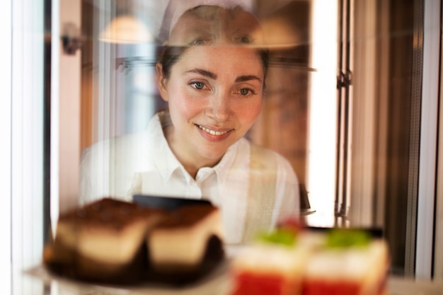 Foto gratuita cerrar mujer sonriente mirando postre