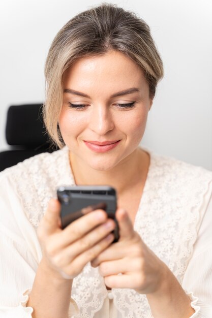 Cerrar mujer sonriente sosteniendo teléfono inteligente