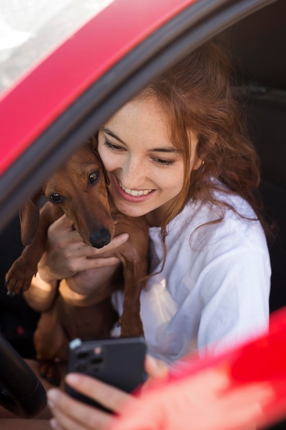 Cerrar mujer sonriente tomando selfie con perro