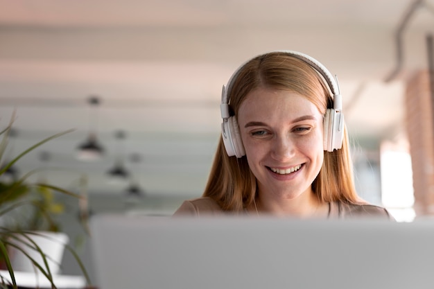 Cerrar mujer sonriente usando audífonos