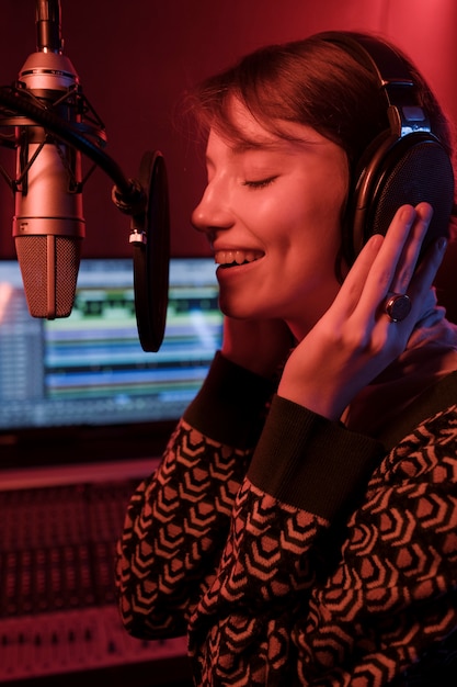 Cerrar mujer sonriente usando audífonos