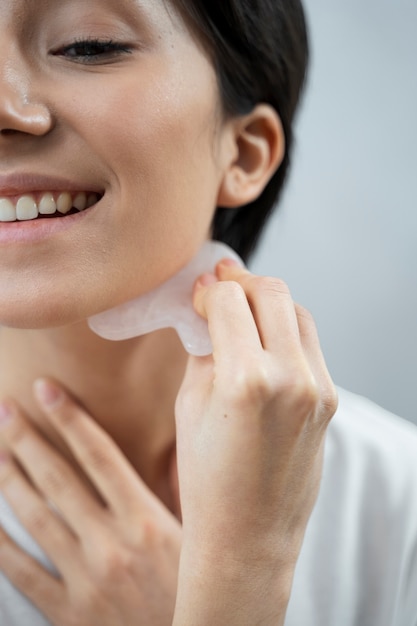 Cerrar mujer sonriente usando la herramienta de cara