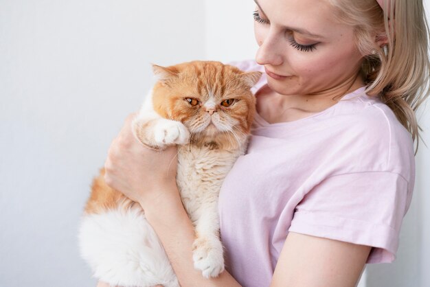 Cerrar mujer sosteniendo adorable gato